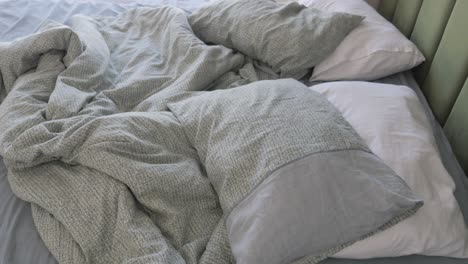 unmade bed with pillows