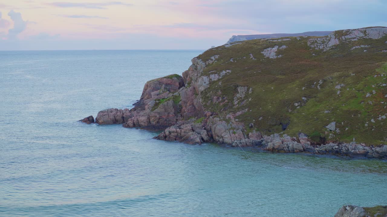hermosa bahía de playa con aguas cristalinas y una tranquila puesta de sol escocesa