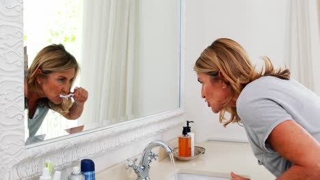 Mujer-Mayor-Cepillándose-Los-Dientes-En-El-Baño.