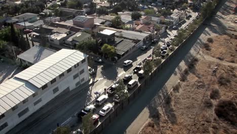 a row of cars is lined up to make a turn and other cars drive around a neighborhood