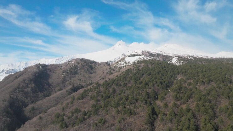 Vetta innevata dell'Etna, volo in avanti, giornata di sole, inquadratura di apertura, Sicilia