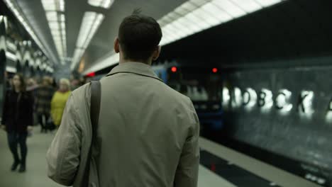 man waiting for train at metro station