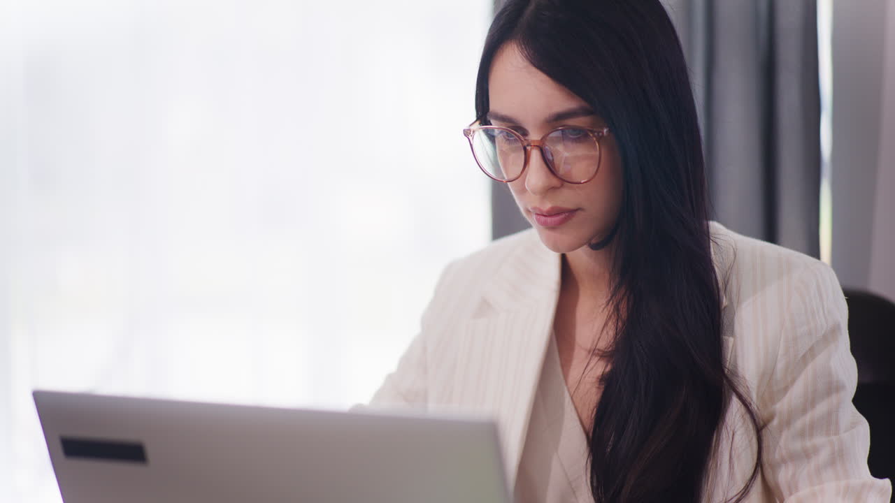 자신감 있는 여성은 노트북으로 일하고 이메일에 응답합니다.