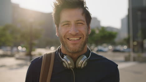 Retrato-De-Cerca-De-Un-Joven-Caucásico-Atractivo-Que-Parece-Confiado-Sonriendo-A-La-Cámara-En-La-Ciudad-Al-Atardecer-Disfrutando-Del-Estilo-De-Vida-Urbano