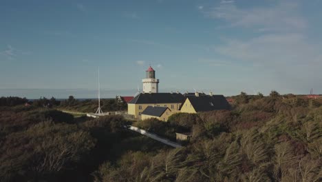 hanstholm fyr, denmark - a panoramic view of lush surroundings encircling the lighthouse - aerial pan up