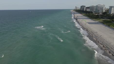 Vista-Aérea-De-Los-Kitesurfistas-Girando-En-Aguas-Poco-Profundas-De-La-Playa-De-Miami