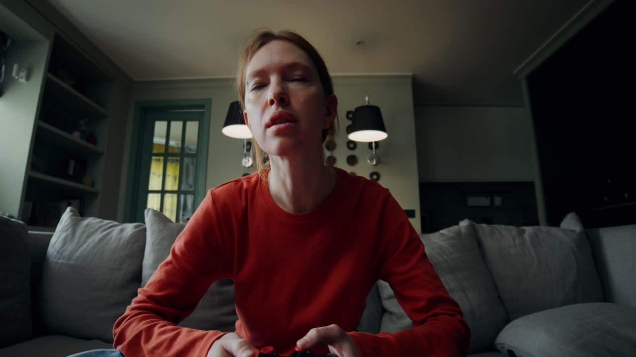 Donna che gioca ai videogiochi a casa