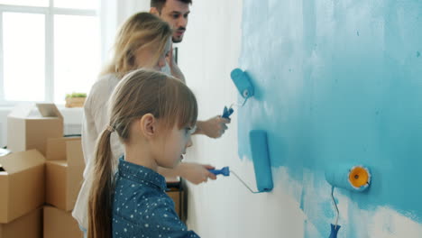 family painting a wall in a new home