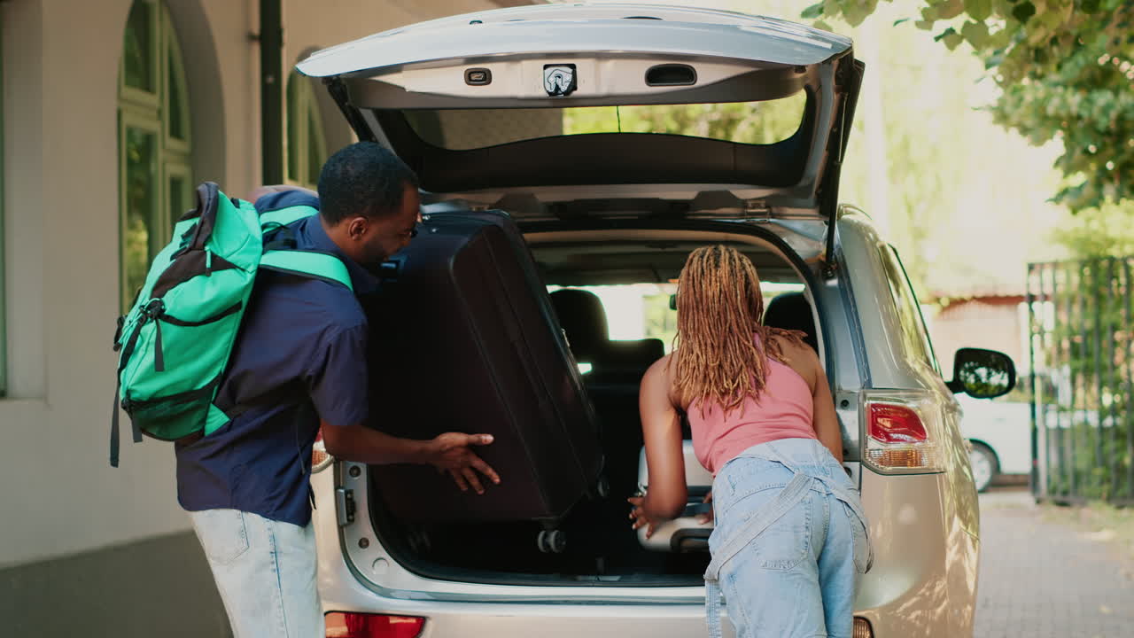 Coppia che prepara i bagagli nel bagagliaio dell'auto per le vacanze