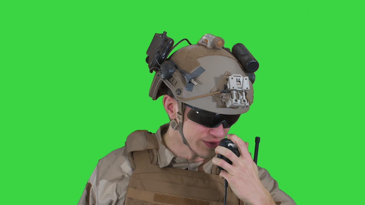 US ranger in uniform talking on radio on a Green Screen, Chroma Key