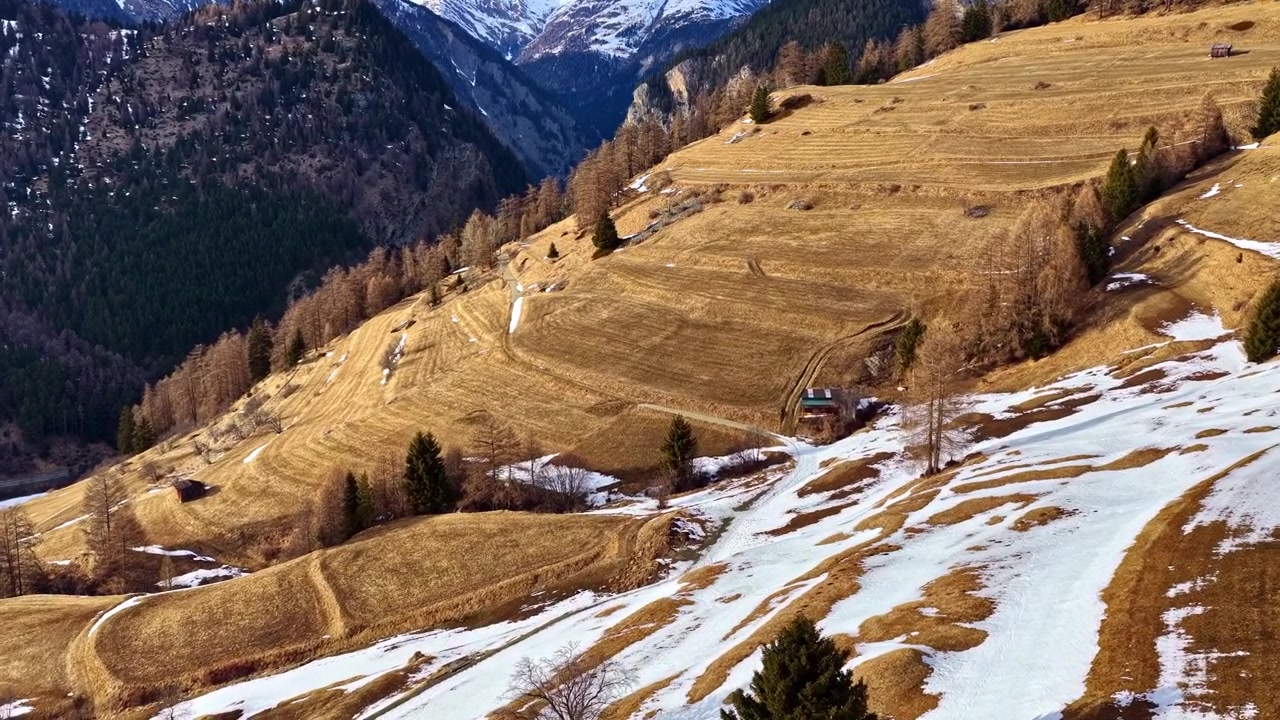 Panoramici pendii montani di Nauders, Austria, con chiazze d'erba e neve in uno splendido paesaggio alpino.