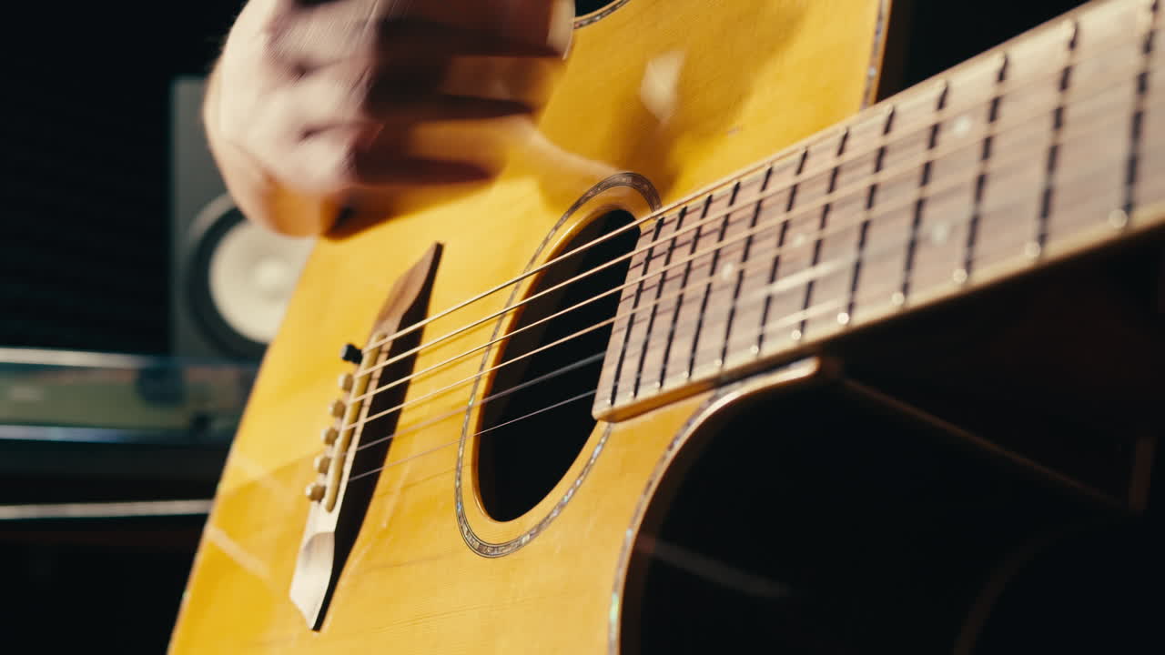 joven músico comprobando las cuerdas de una guitarra acústica de cerca. guitarrista masculino afinando el sonido de un instrumento musical.