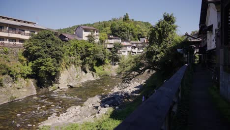 Japanese-Homes-Along-the-Yoshida-River-in-Gujo-Hachiman-City,-Warm-Summer-Day