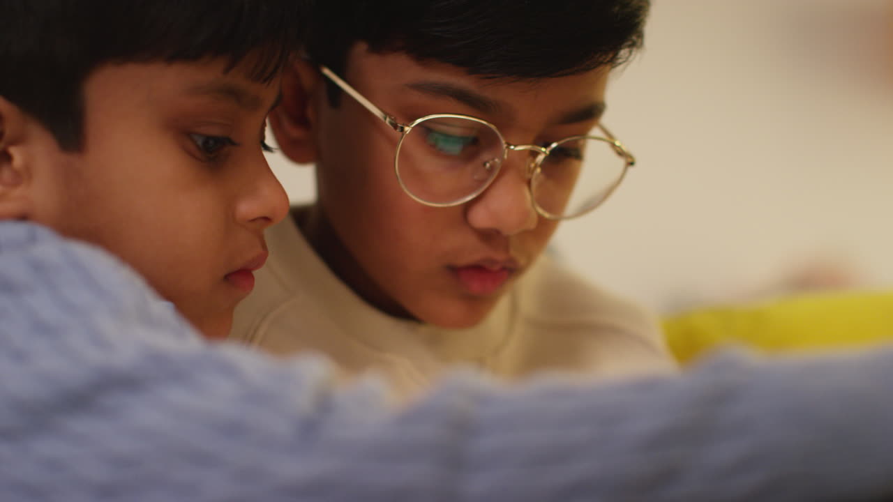 Two Young Boys Sitting On Sofa At Home Playing Games Or Streaming Onto Digital Tablet 5