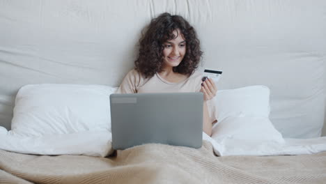 woman shopping online in bed