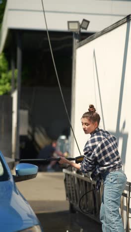 woman washing a car at a self-service car wash