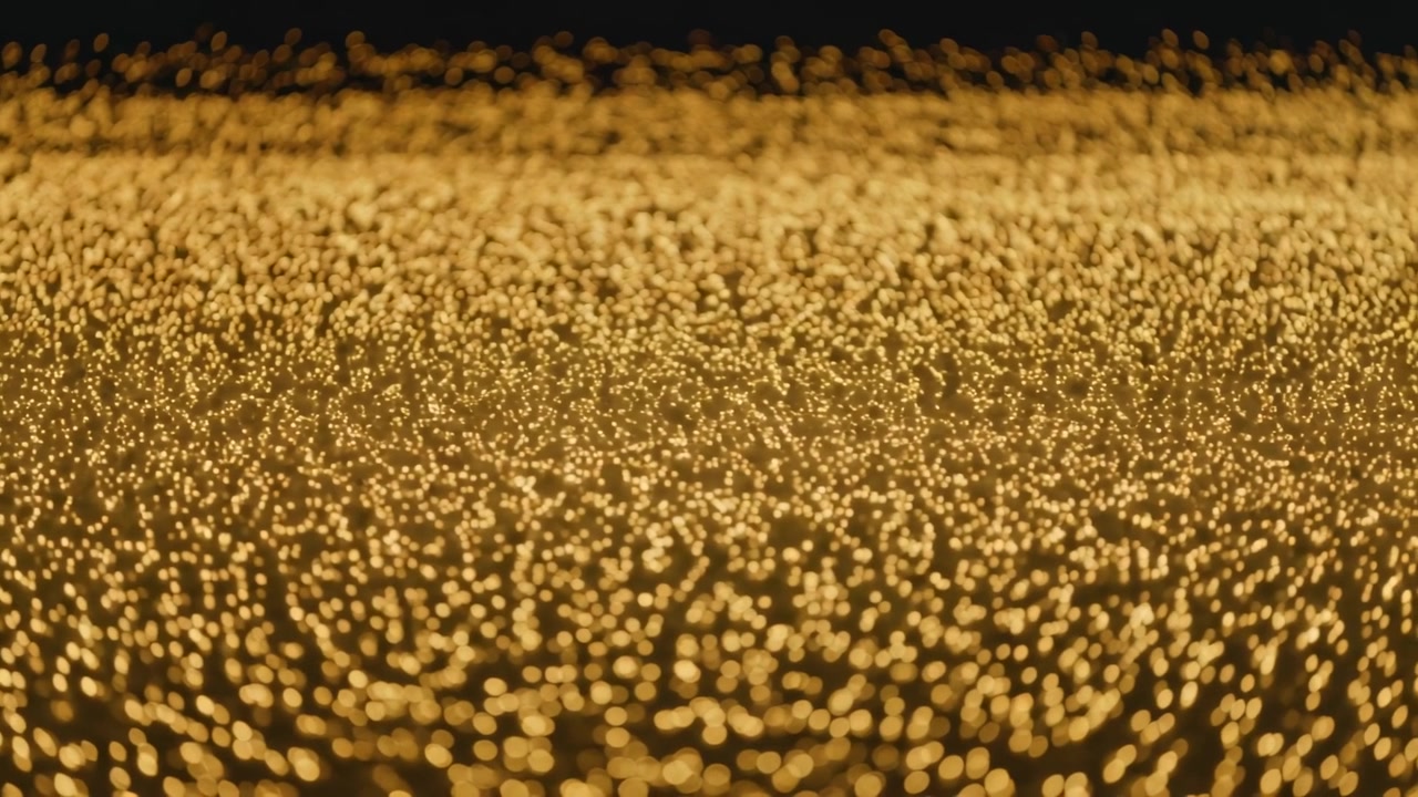 Un denso campo scintillante di punti bokeh caldi e dorati che si muovono con i cambi di messa a fuoco in primo piano, fascia superiore.