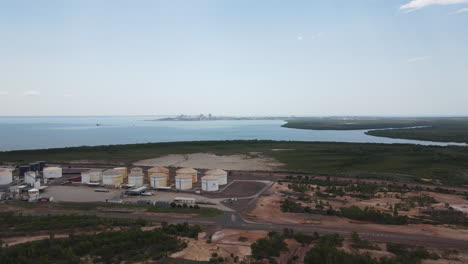 Slow-Rotating-Drone-shot-of-East-Arm-Industrial-Area-and-Oil-Storage-moving-Towards-Darwin-Skyline-and-City,-Northern-Territory