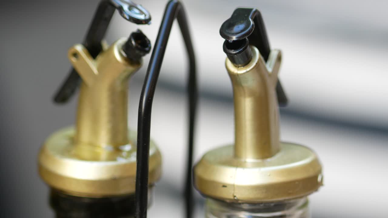 Close-up of Two Gold and Black Oil Dispensers