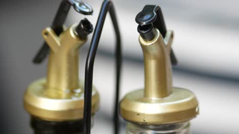 close-up of two gold and black oil dispensers