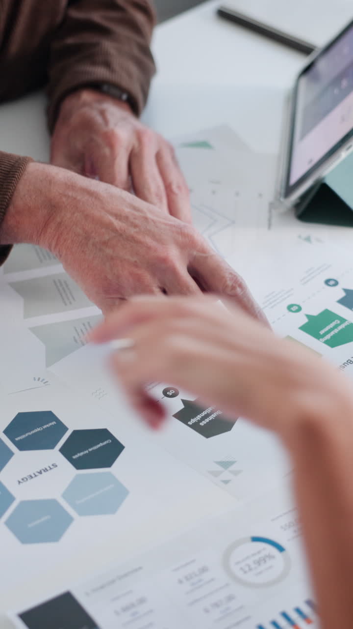 Hands Analyzing Business Documents and Marketing Strategy