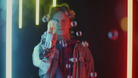 young person blowing bubbles in neon lights