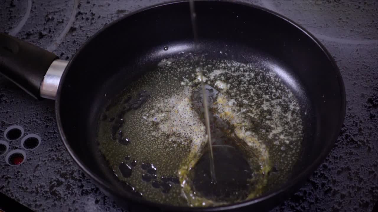 Fried egg. Raw egg on the frying pan in slow motion.