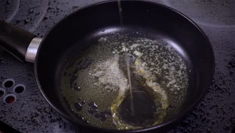 huevo frito. huevo crudo en la sartén en cámara lenta.
