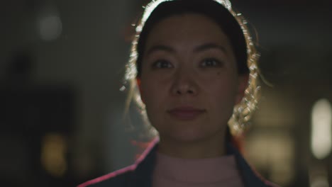 close up of woman visiting and interacting with immersive art exhibition backlit by light from projector 3