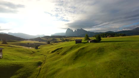 Imágenes-Aéreas-De-Drones-Fpv-Volando-Rápido-Entre-árboles-Y-Cabañas-En-La-Meseta-De-Alpe-Di-Siusi,-Seiser-Alm,-Montañas-Dolomitas,-Alpes-Italianos