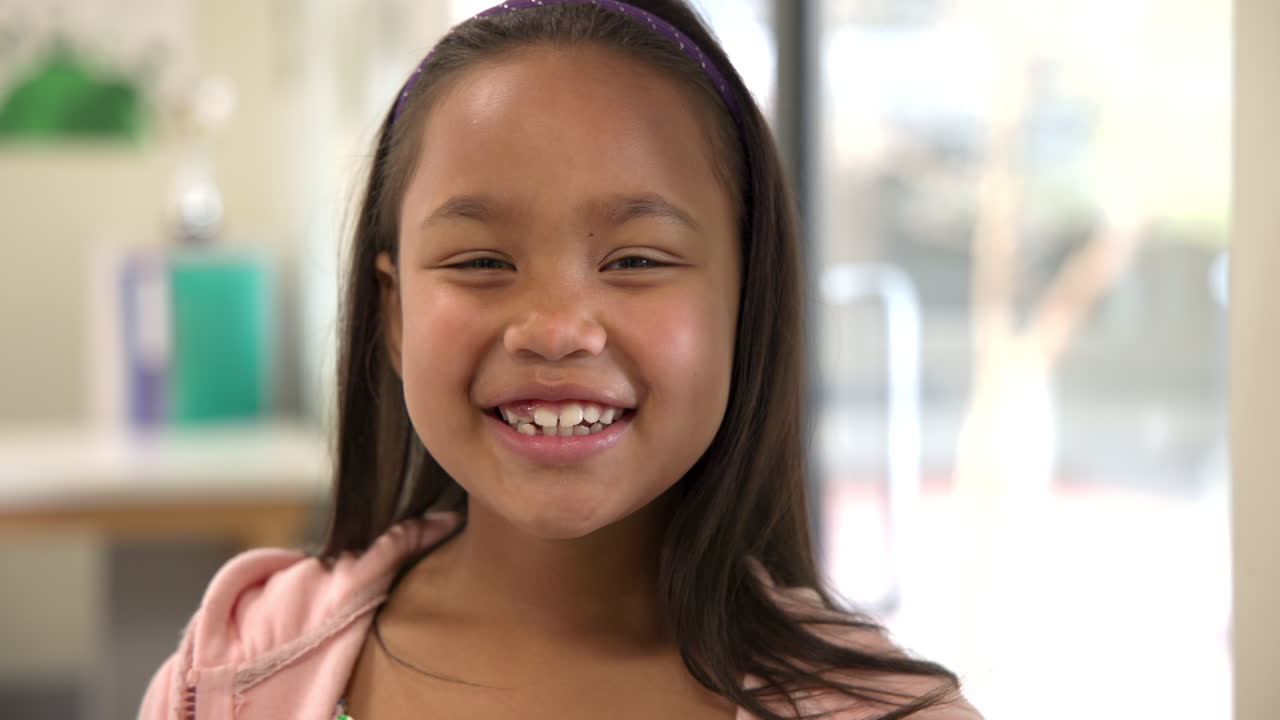 In school classroom, smiling girl feeling confident and happy while ...
