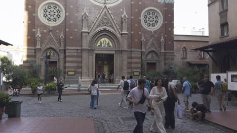static medium shot of the church of st. anthony of padua, capturing its grand facade with people walking in the busy square