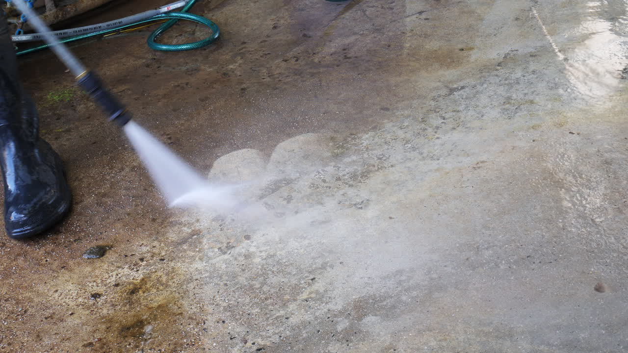 High pressure jet washing dirt of concrete flooring