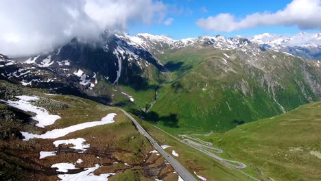 aerial shot of nufenenpass early summer with unmelted patches of snow