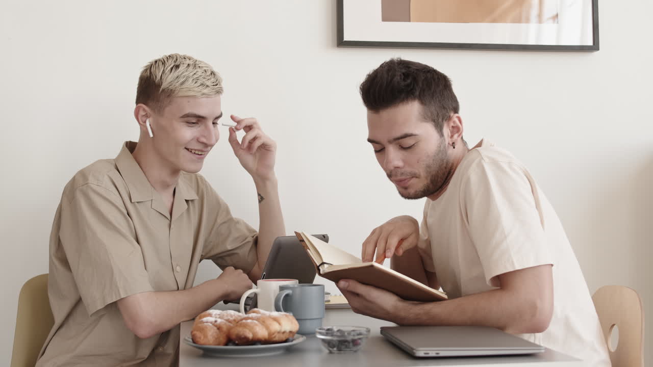 Two Young Men Sitting in the Kitchen and Chatting