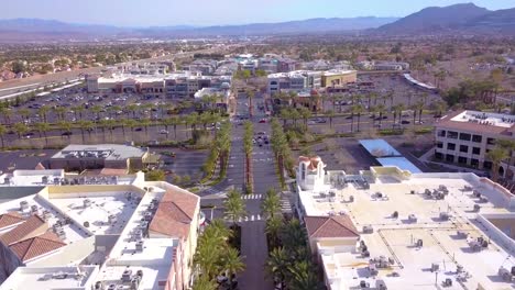 aerial view flying over entertainment complex with palm trees, street, traffic