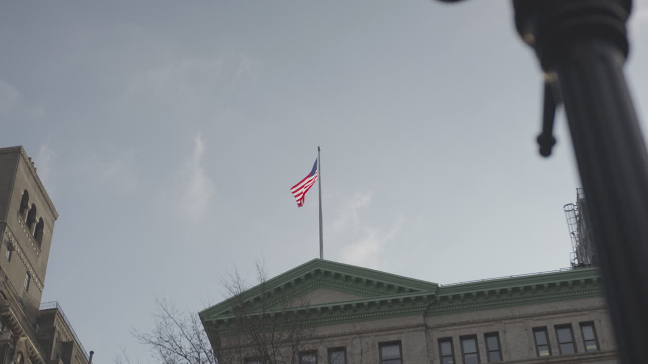 The flag blows in the wind above the building
