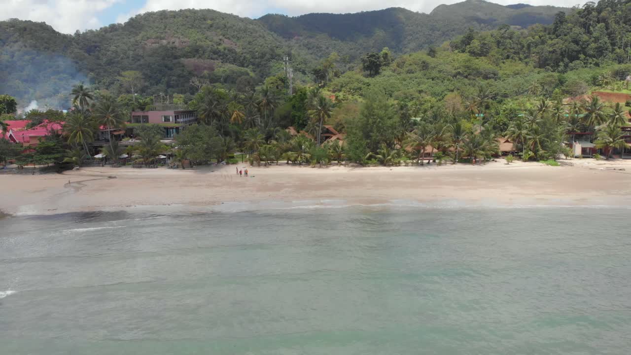 un turista familiar que pasa tiempo caminando por la playa con su perro mascota disfrutando del sol de verano en koh chang, tailandia