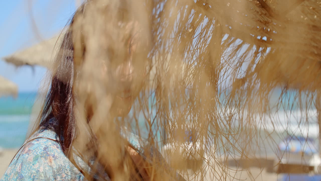 해변 우산 에 웃는 예쁜 젊은 여인