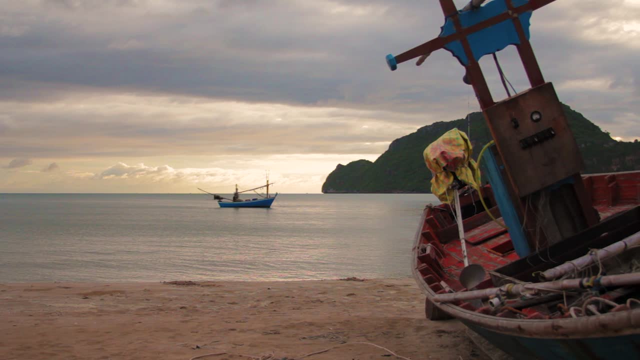 foto de plataforma rodante de un barco pesquero tailandés en la playa durante el amanecer.