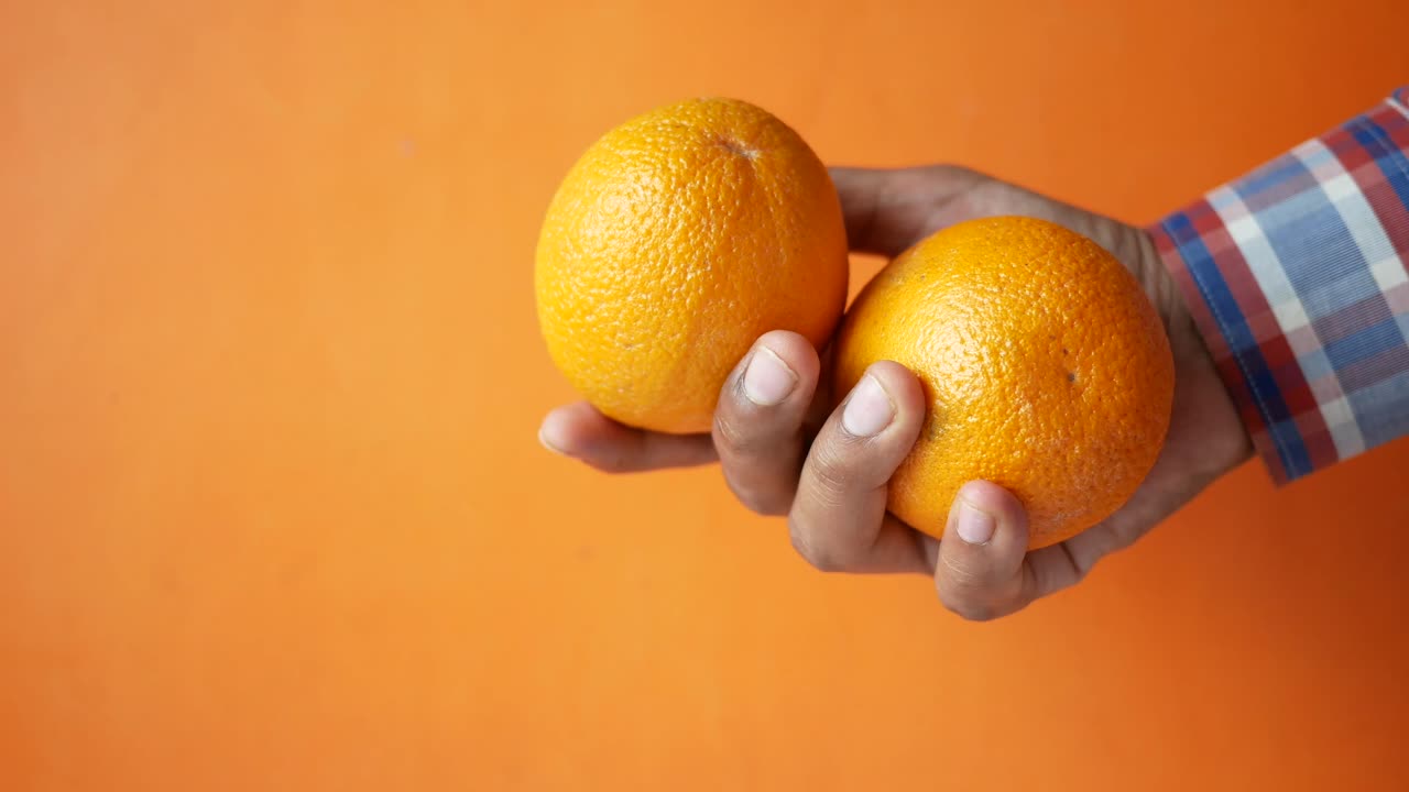 dos naranjas en la mano