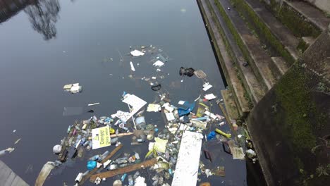 rubbish dumped and floating in disused dock woolwich london uk
