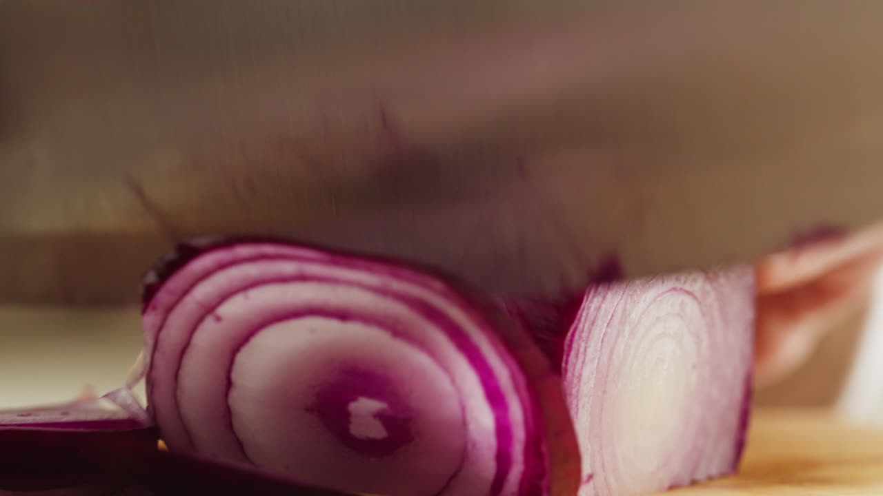 Close-up of a Hand Slicing Red Onion with a Knife