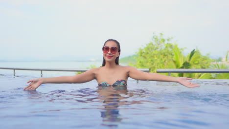 Silly-asian-girl-playing-in-swimming-pool-with-ripples