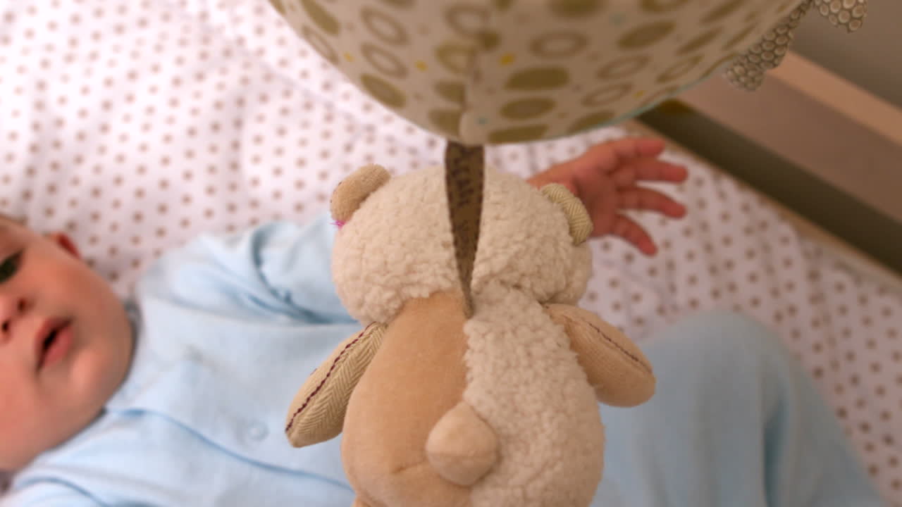 아기가 침대에서 휴대전화로 놀고 있다