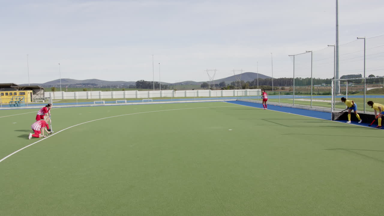Female hockey players preparing for penalty corner on outdoor field