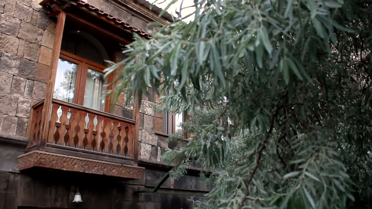 Esterno di un edificio dal design tradizionale con un albero vicino alle finestre a Gyumri Yuriy, Armenia - Campo lungo