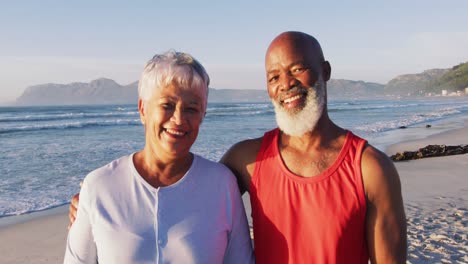 Portrait-of-senior-african-american-couple-embracing-and-smiling-at-the-beach