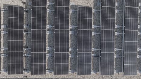aerial top down view of new building project with solar panels mounted on the roof using photo-voltaic cells which use sunlight as a source of energy (4k)