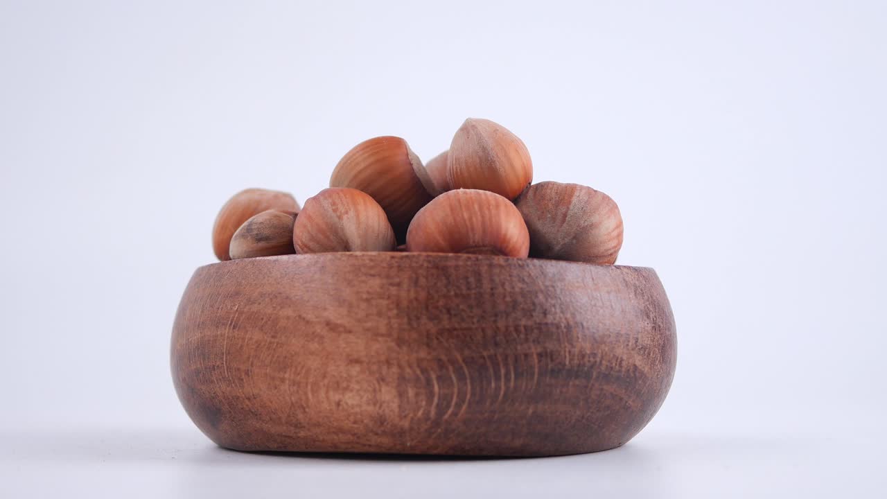 Raccolta a mano di una nocciola da una ciotola di legno
